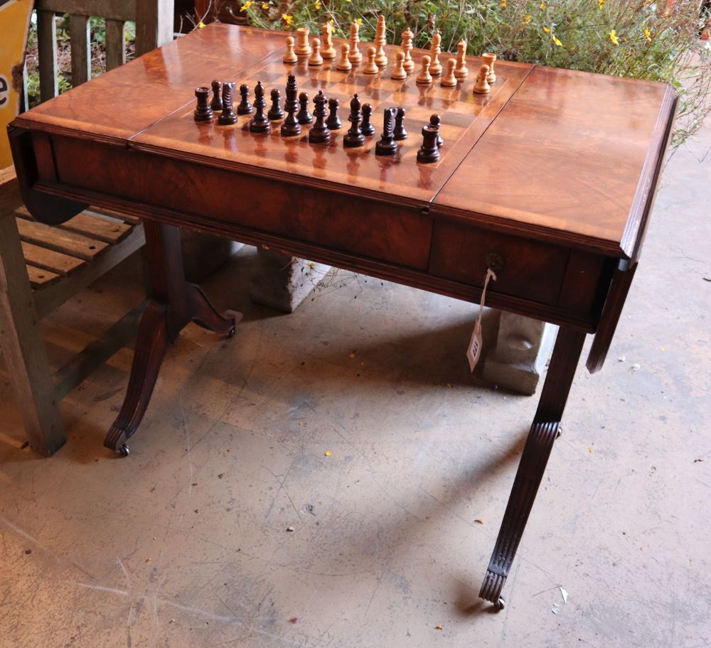 A George III style walnut sofa / games table with sliding reversible top, includes chess and backgammon pieces, width 94cm depth 60cm